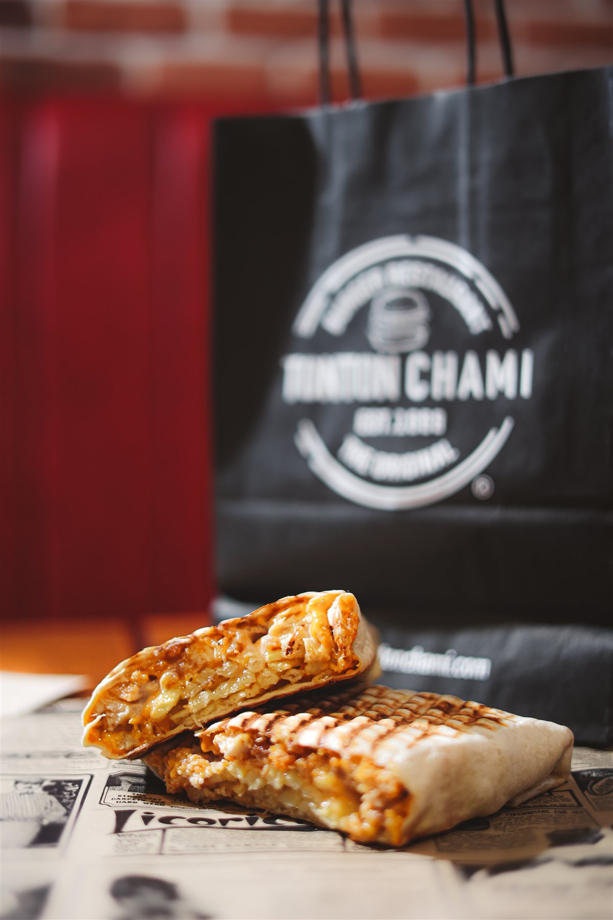 Tacos Tonton Chami coupé en deux devant un sac de la marque