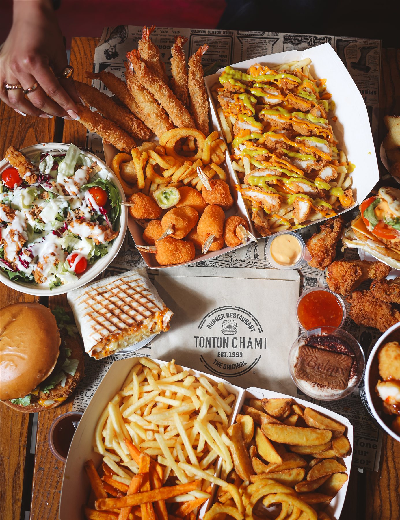 Tablée généreuse de burgers, frites, tenders et salade Tonton Chami